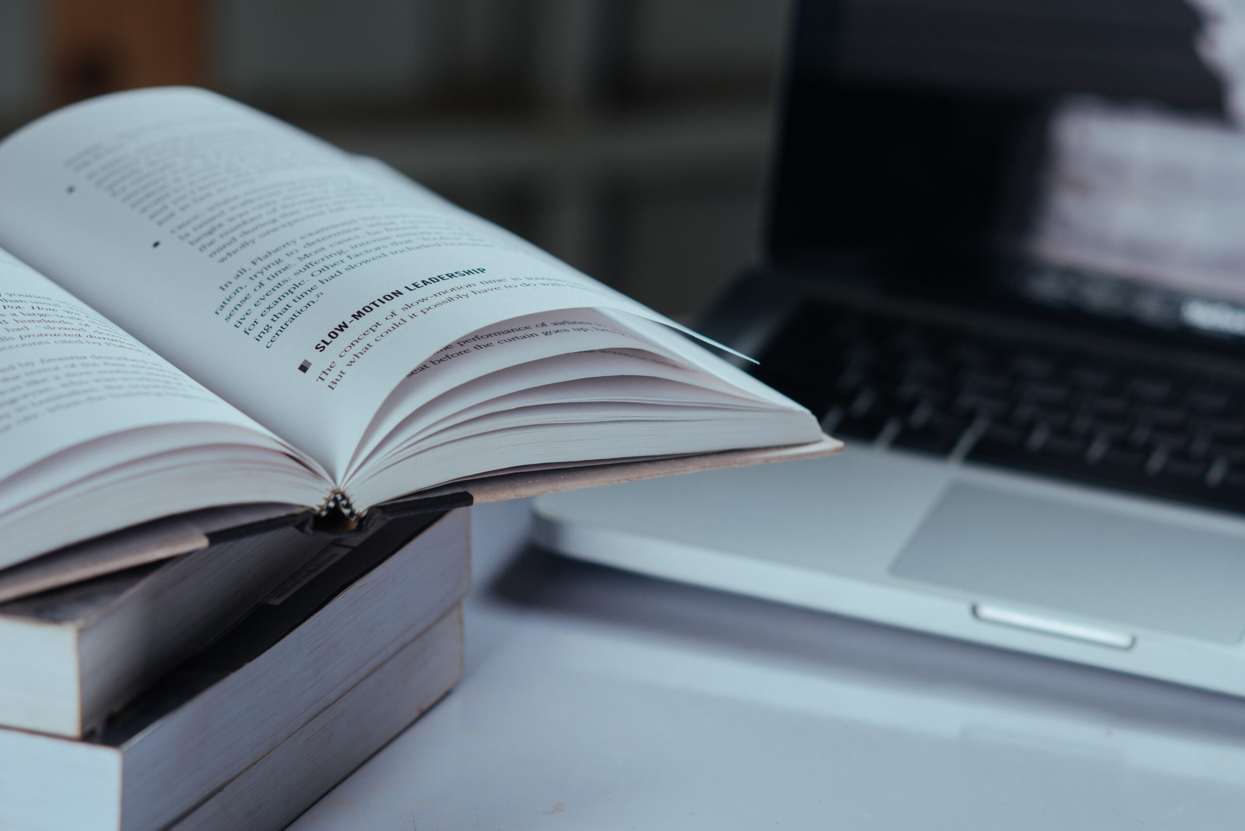 An open book resting on a laptop